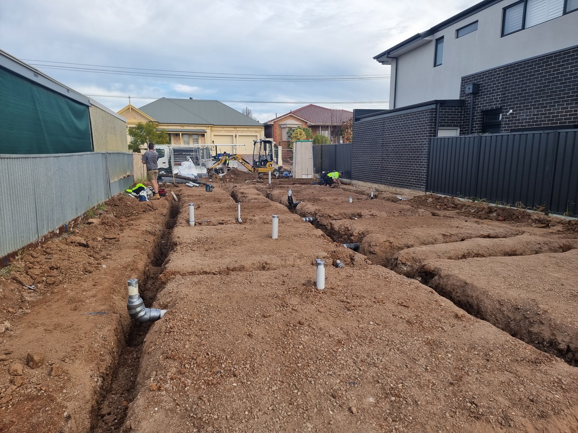 Sewer and stormwater rough-in trenches set out to fall
