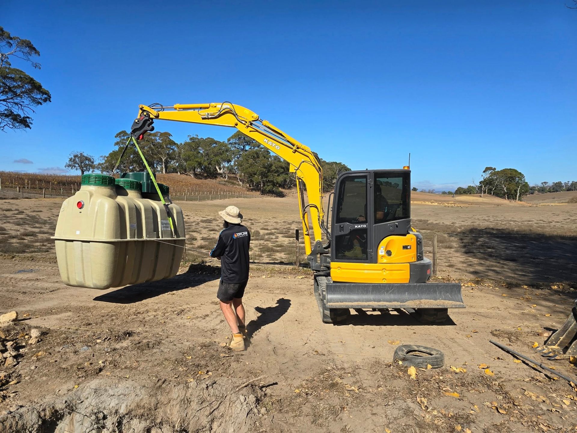 Crane lifting a fibreglass septic tank into a rural property install